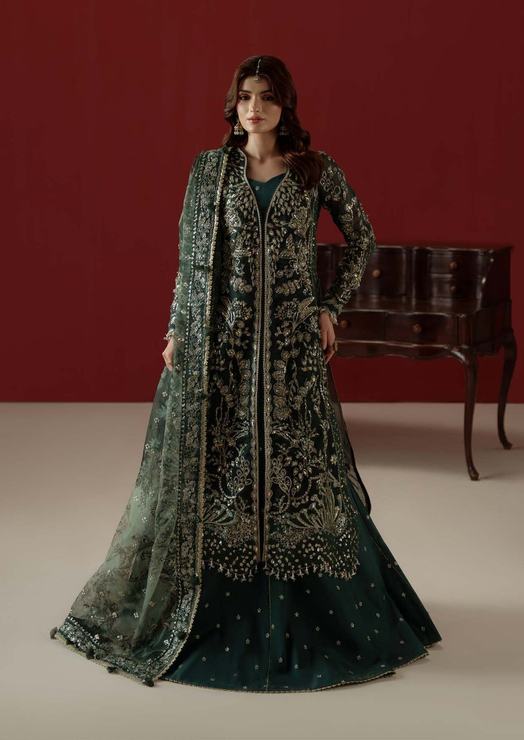 Elysee standing, front view against a deep red wall