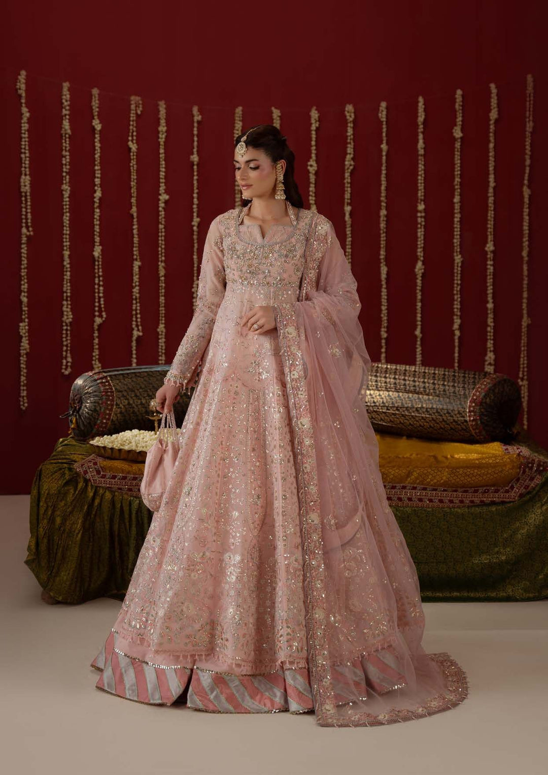 Lovelorn: a blush-pink long frock-style shirt with a striped hem, standing beside a divan